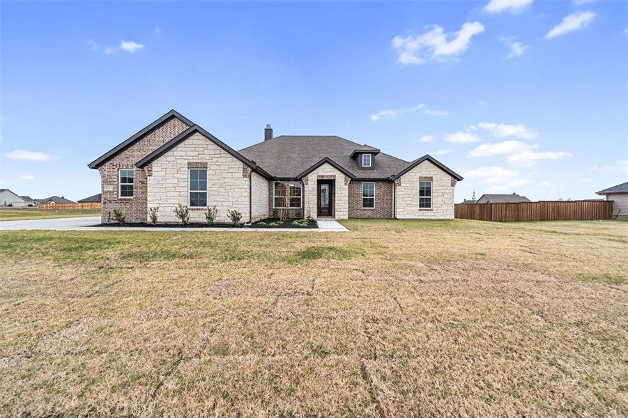 French provincial home featuring stone siding and a shingled roof