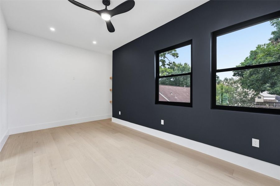 Inside a dramatic charcoal accent wall and oversized windows frame elevated treetop views while filling the room with natural light.