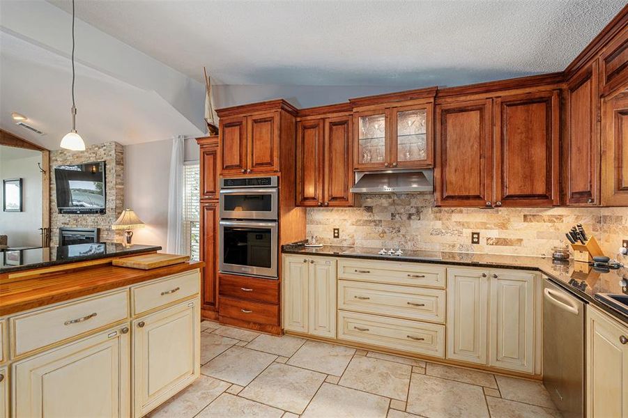 Kitchen featuring two-tone cabinetry, stainless steel built-in double ovens, and a tile backsplash