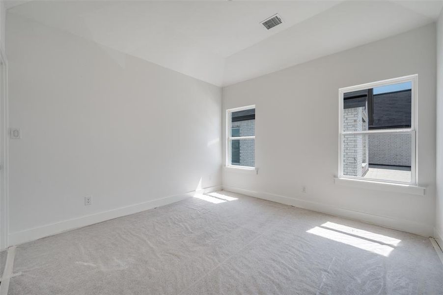 Unfurnished room with light carpet and plenty of natural light