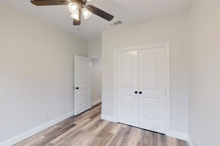 Unfurnished bedroom with a closet, ceiling fan, and light wood-type flooring