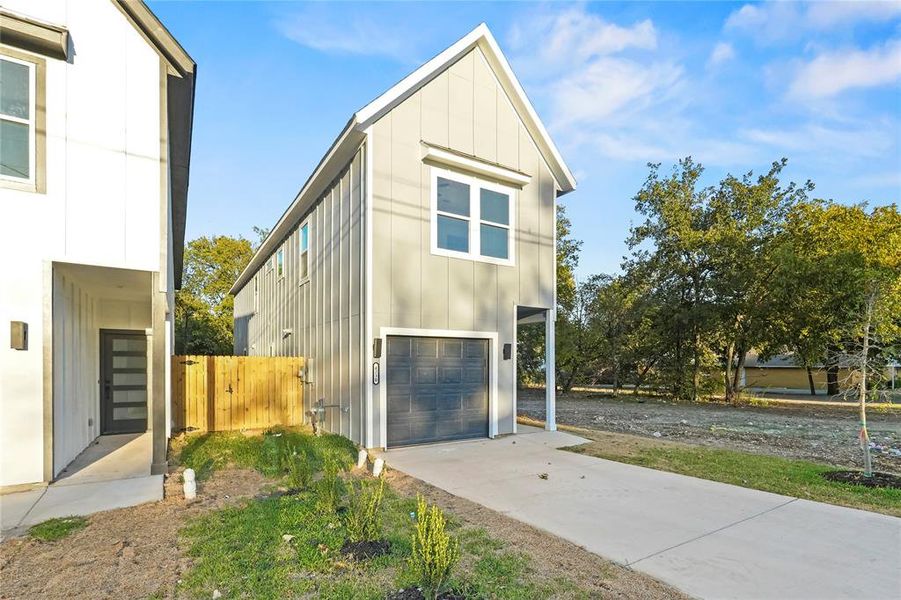 View of property exterior with board and batten siding, a garage, and concrete driveway View of property exterior with board and batten siding, a garage, and concrete driveway