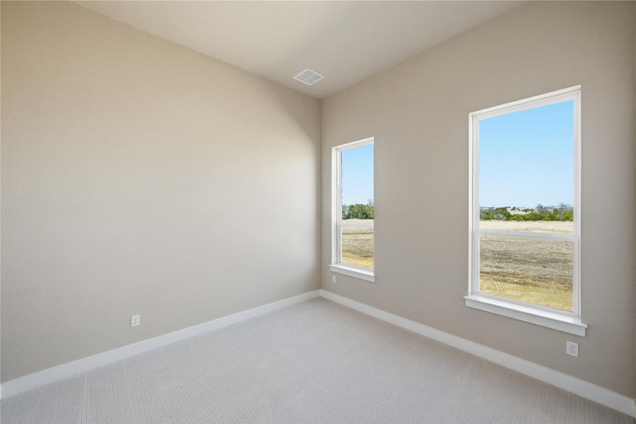 Spare room featuring carpet flooring and baseboards