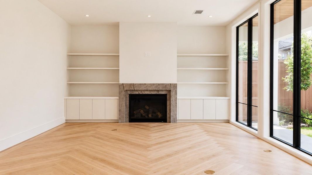 Living room with fireplace and large floor to ceiling windows.