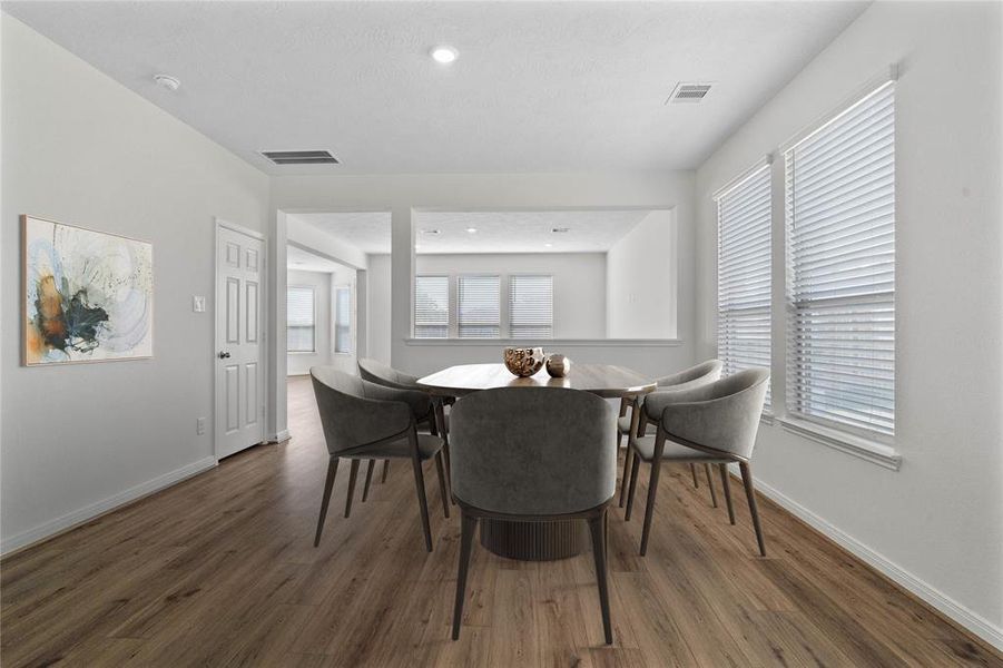 This formal dining area features high ceilings, recessed lighting, large windows with privacy blinds, and tile flooring!