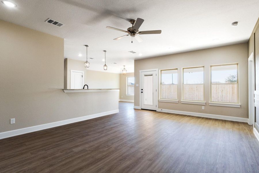 Unfurnished living room featuring ceiling fan, dark wood finished floors, and recessed lighting