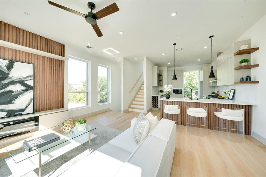 Living room with light hardwood / wood-style floors, sink, and ceiling fan