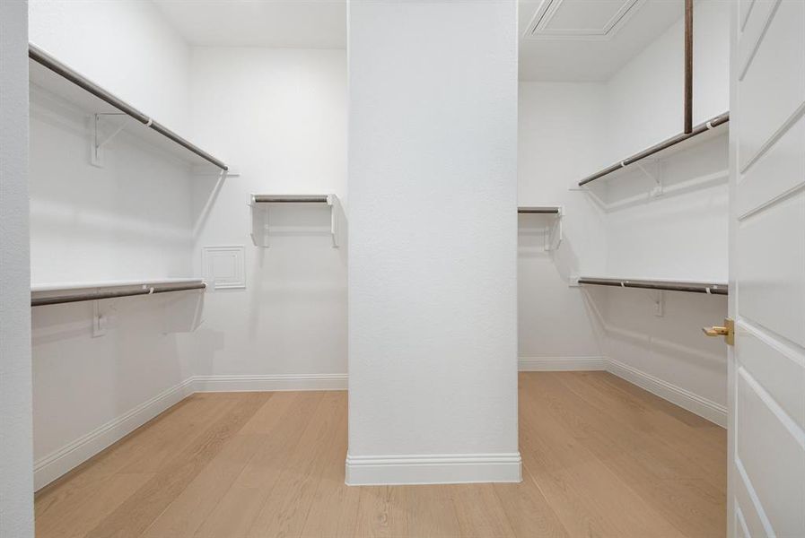 Walk in closet with light wood finished floors