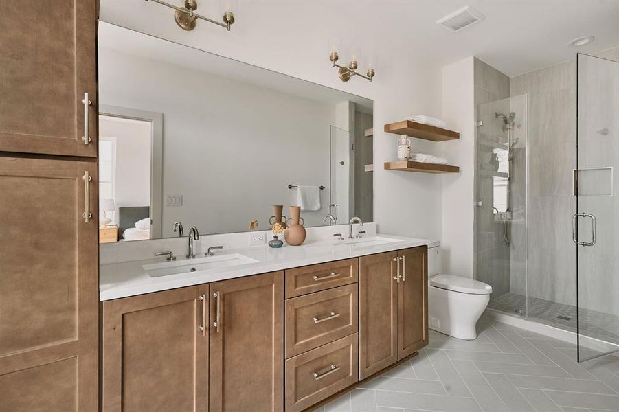 Spacious bathroom featuring a double vanity with quartz countertops, integrated sinks, and brushed nickel fixtures