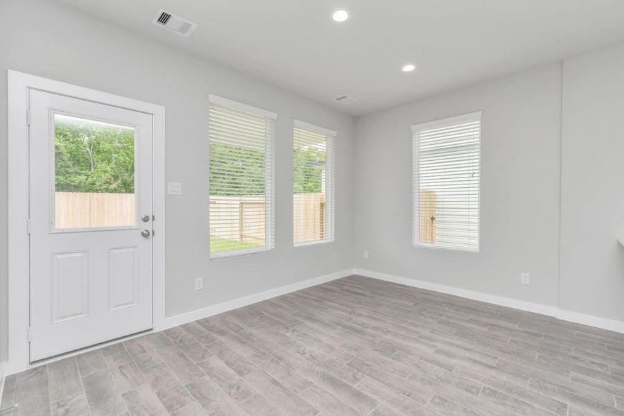 Enjoy breakfast with ease in the connected and cozy breakfast area, seamlessly integrated with the kitchen for utmost convenience. Step through the back door for a breath of fresh air onto the covered patio, extending your living space to the outdoors. Sample photo of completed home with similar floor plan. Actual colors and selections may vary.