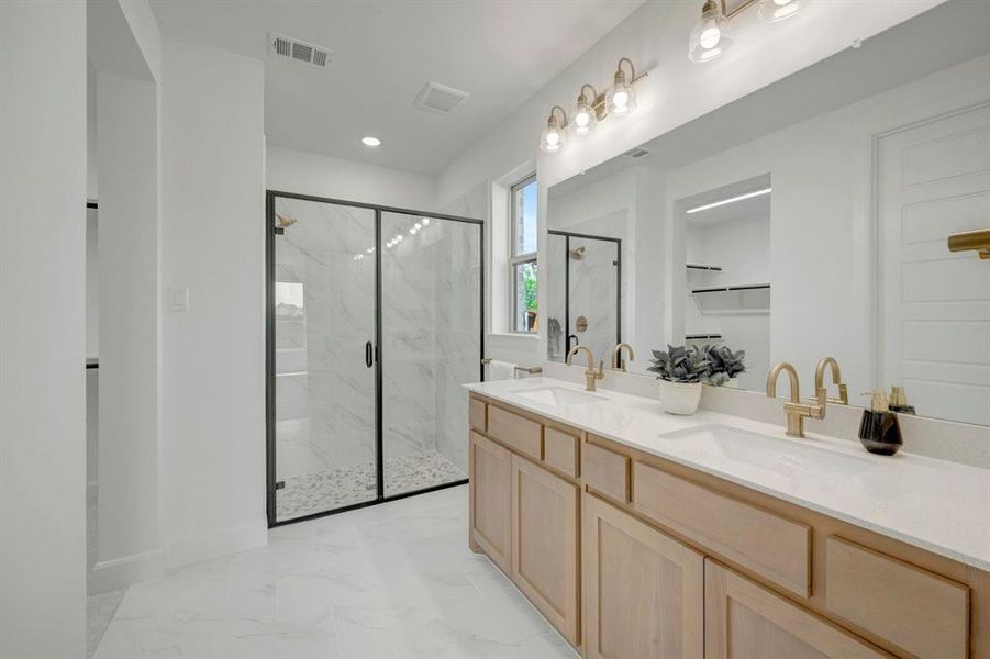 Modern bathroom featuring a dual vanity with light wood-finish cabinetry and white countertops