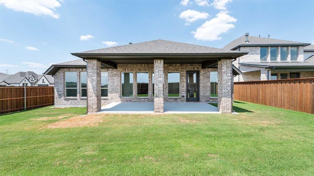 Back of property with a lawn and a patio