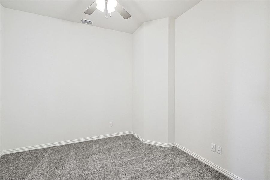 Carpeted empty room with ceiling fan