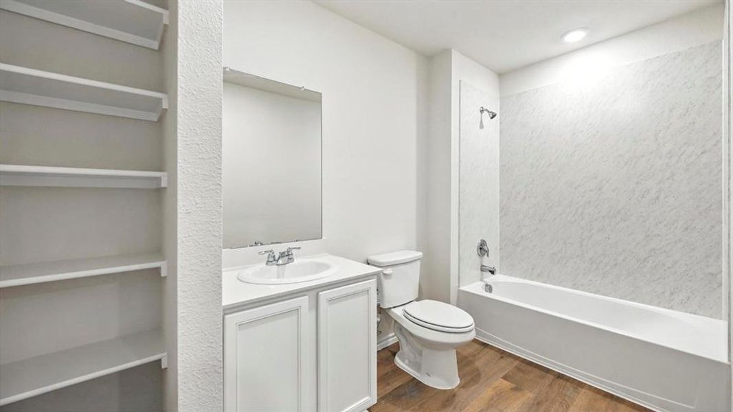Bathroom featuring a white vanity with integrated sink, chrome faucet, and rectangular wall mirror