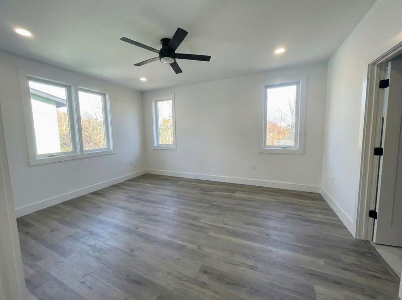 Empty room with dark wood finished floors, recessed lighting, and a ceiling fan