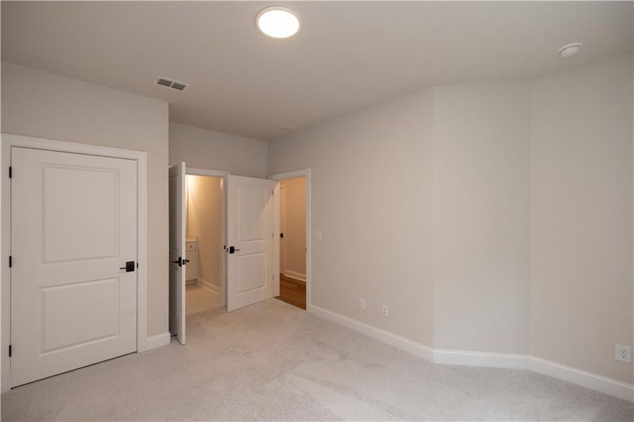 Unfurnished bedroom with light carpet