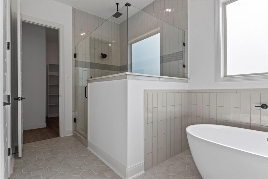 Primary bathroom with dual vanity and soaking tub.