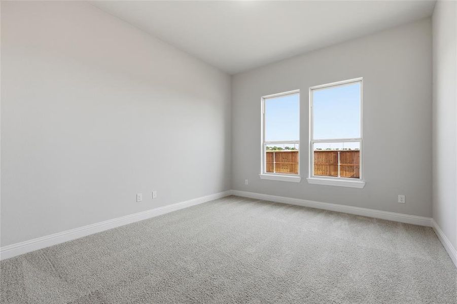 Empty room featuring light colored carpet and baseboards Empty room featuring light colored carpet and baseboards