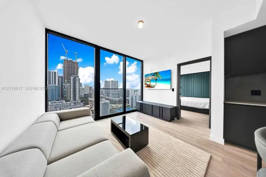 Floor-to-ceiling windows, wood-finish flooring, and black cabinetry Floor-to-ceiling windows, wood-finish flooring, and black cabinetry