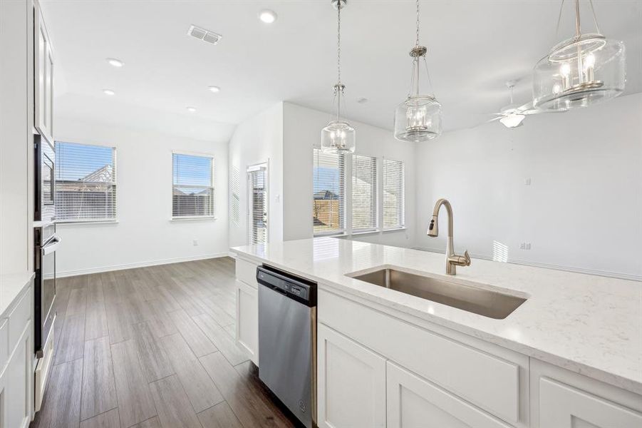 Kitchen featuring white cabinets, appliances with stainless steel finishes, sink, and light stone counters