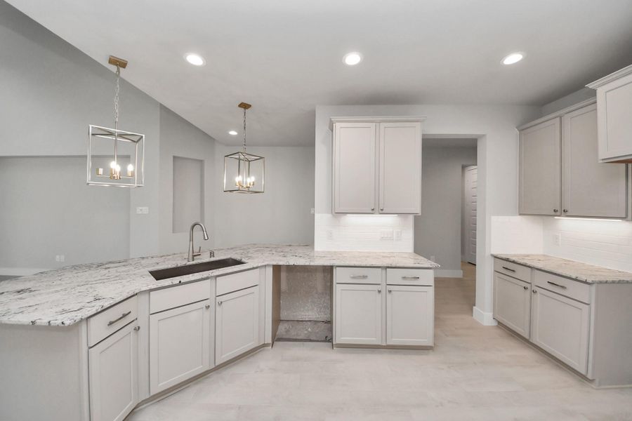 The kitchen is a culinary haven, featuring granite countertops, a tile backsplash, stainless steel appliances, 42” upper cabinets, and undercabinet lighting. The kitchen is a culinary haven, featuring granite countertops, a tile backsplash, stainless steel appliances, 42” upper cabinets, and undercabinet lighting.