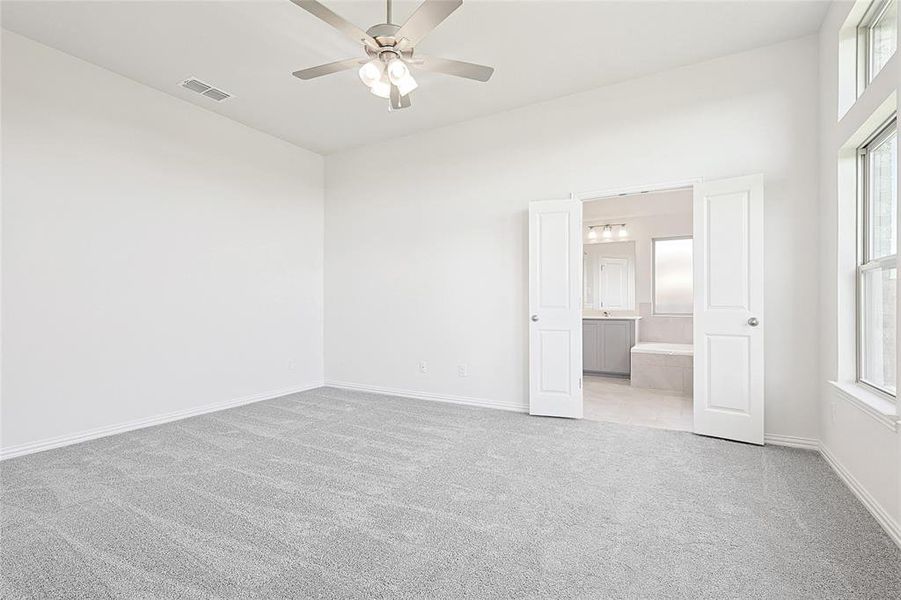 Carpeted spare room featuring ceiling fan