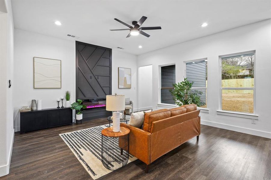 Living room featuring dark wood-type flooring and ceiling fan