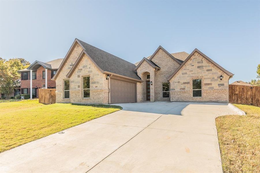 View of front of house with a garage and a front lawn