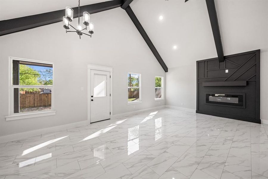 Unfurnished living room featuring suspended lighting and a fireplace
