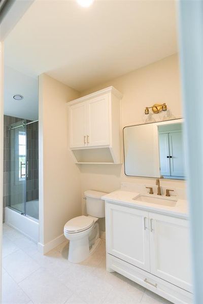 Bathroom featuring a white vanity with integrated sink, gold-finish faucet, and coordinating mirror with gold-finish light fixture