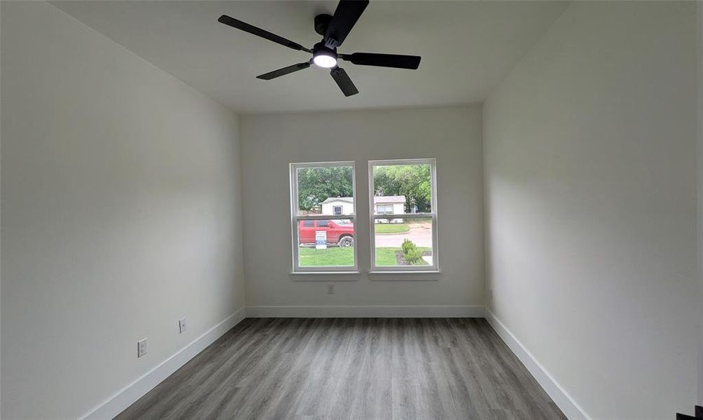 Spare room with baseboards, a ceiling fan, and wood finished floors
