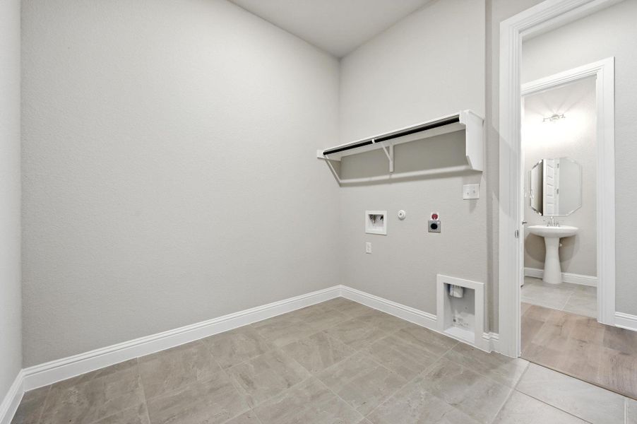 Washroom featuring gas dryer hookup, washer hookup, light tile patterned floors, and hookup for an electric dryer