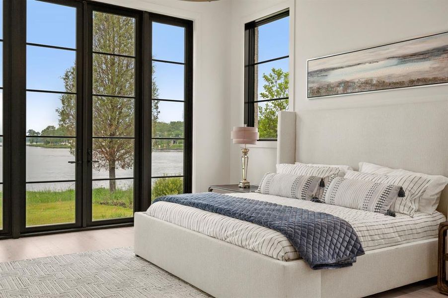 Bedroom featuring a water view and wood finished floors Bedroom featuring a water view and wood finished floors