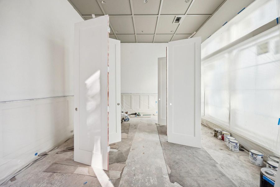 Large formal dinining room with wainscoting panels and unique ceiling detail.