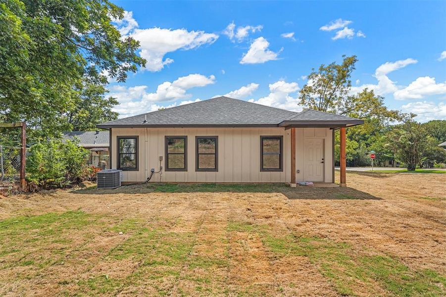 Rear view of property with a yard and central AC unit