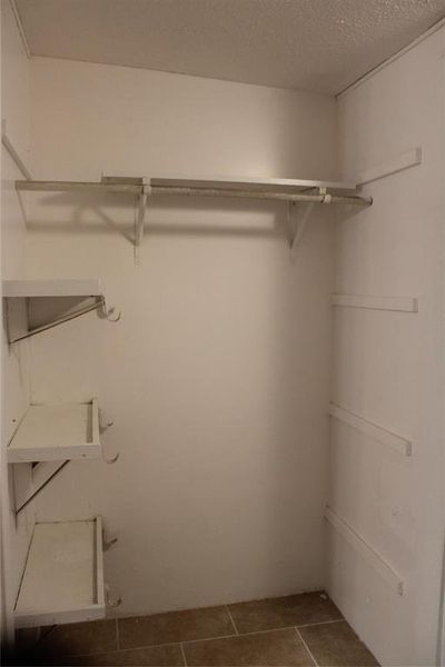 Spacious closet featuring dark tile patterned floors Spacious closet featuring dark tile patterned floors