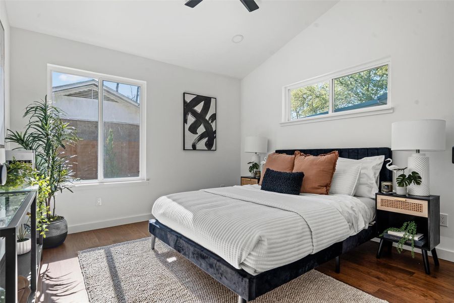 Bedroom featuring vaulted ceiling, dark wood-style flooring, and a ceiling fan