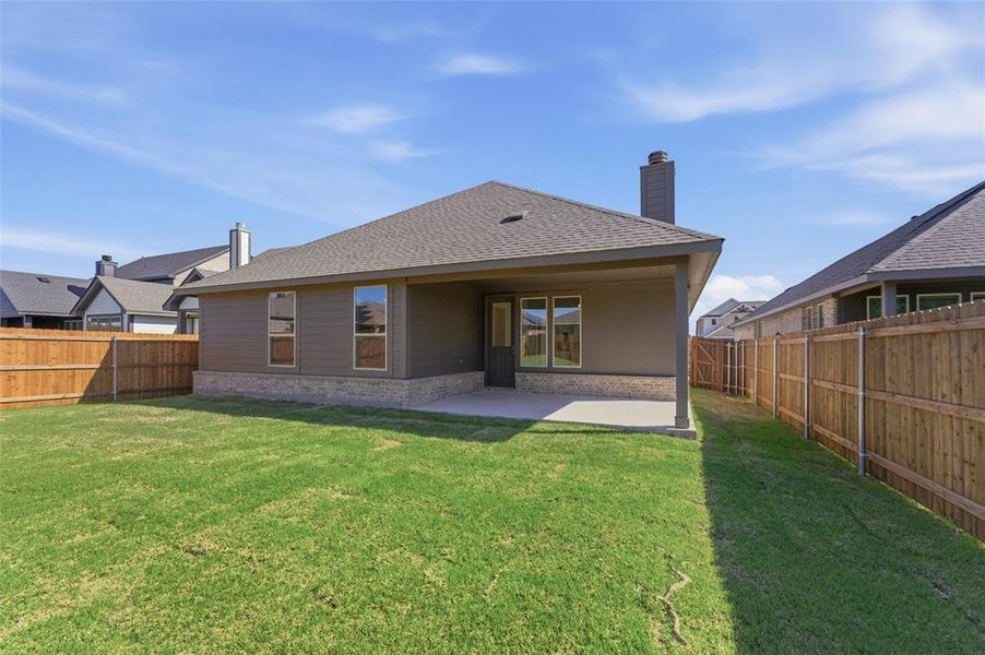 Rear view of property featuring a patio, roof with shingles, a fenced backyard, and a chimney