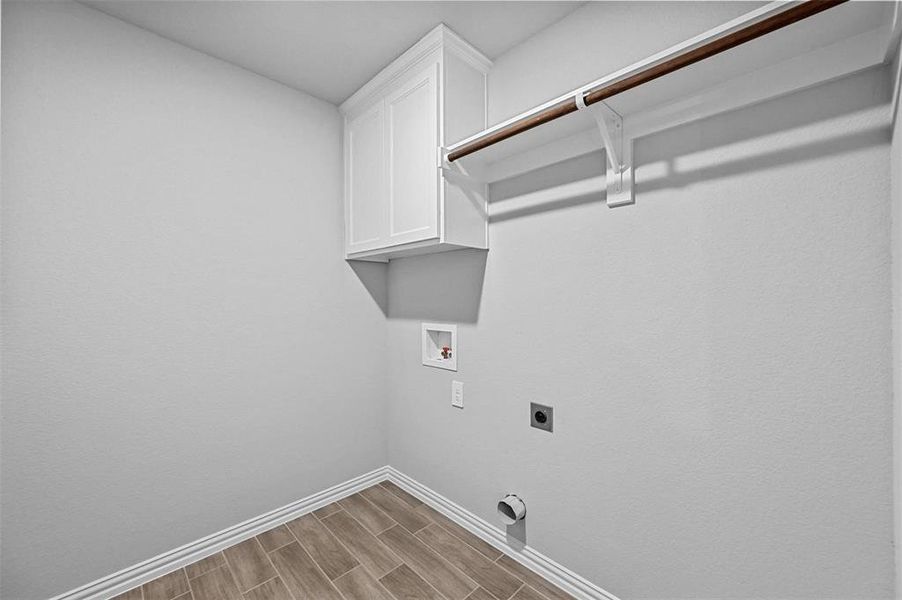 Laundry area with wood tiled floors, cabinet space, washer hookup, and hookup for an electric dryer Laundry area with wood tiled floors, cabinet space, washer hookup, and hookup for an electric dryer