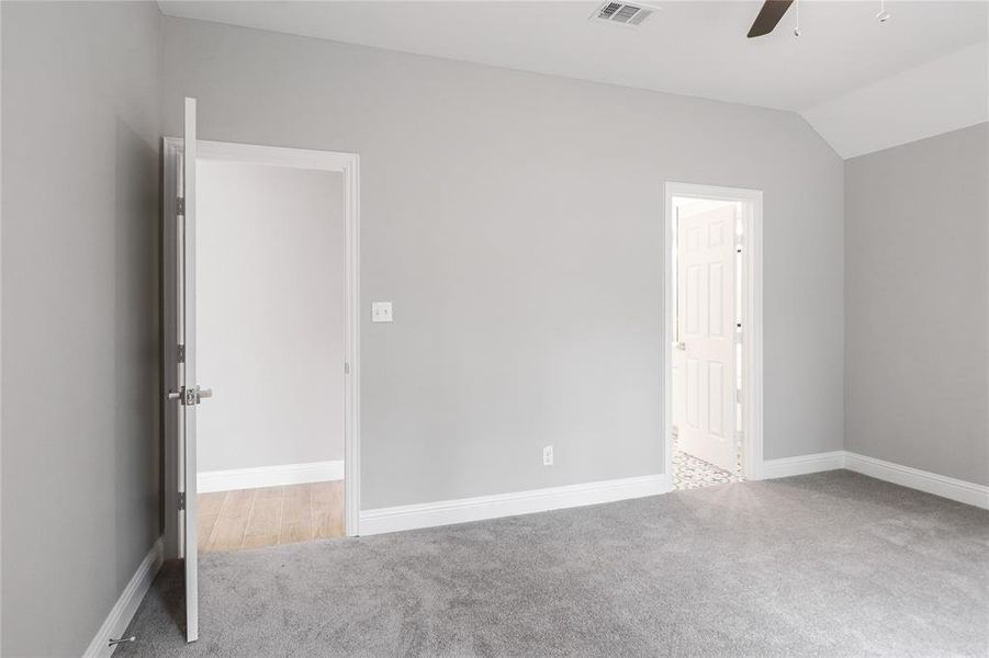 Unfurnished bedroom featuring lofted ceiling, light colored carpet, and ceiling fan