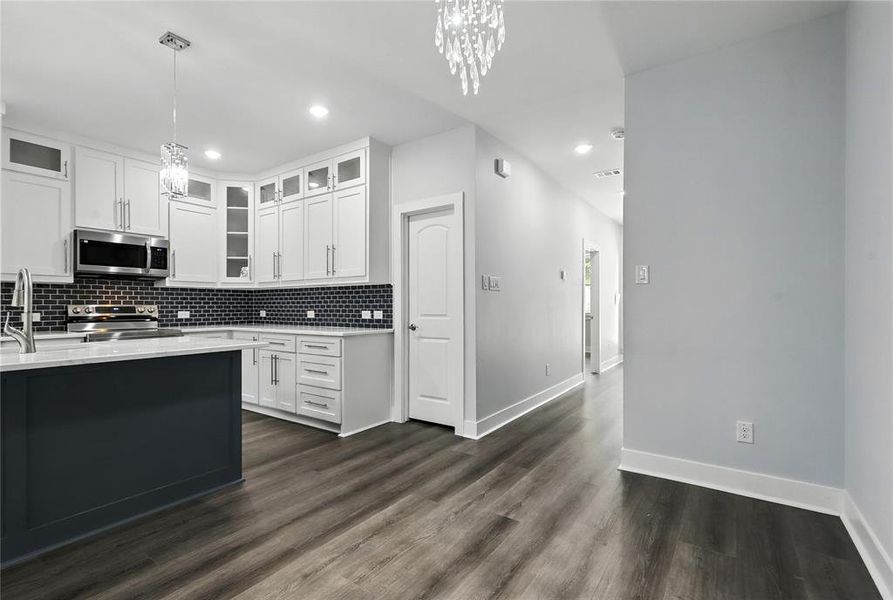 Kitchen featuring a chandelier, backsplash, light countertops, appliances with stainless steel finishes, and recessed lighting