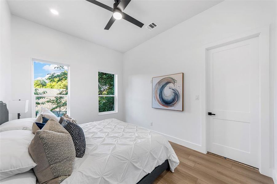 Bedroom with light wood finished floors, a ceiling fan, and recessed lighting Bedroom with light wood finished floors, a ceiling fan, and recessed lighting