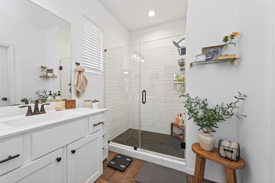 This bathroom features a modern design with a spacious glass frameless shower, white subway tiles, and a sleek vanity with dual faucets. This bathroom features a modern design with a spacious glass frameless shower, white subway tiles, and a sleek vanity with dual faucets.