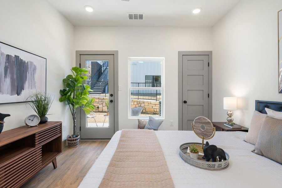 Bedroom featuring wood finished floors, access to exterior, and recessed lighting