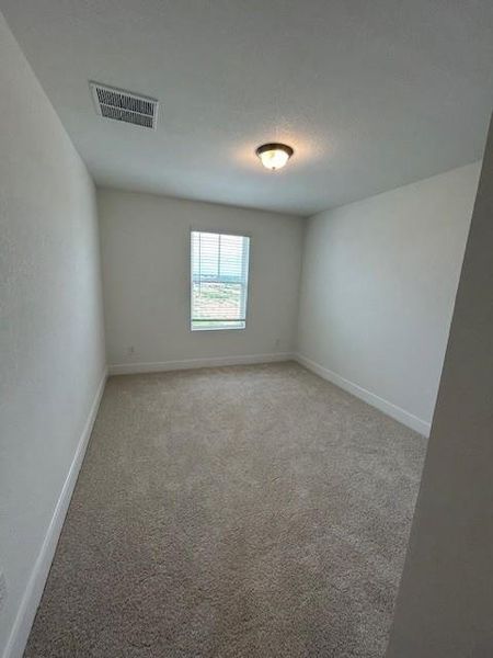 Empty room featuring visible vents, baseboards, and light colored carpet