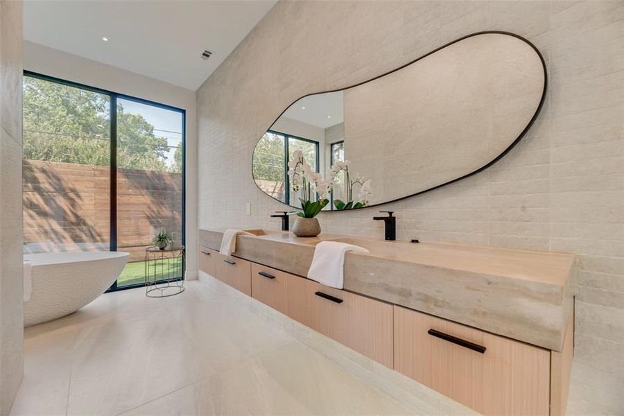 Bathroom featuring tile walls, tile patterned floors, vanity, and a healthy amount of sunlight