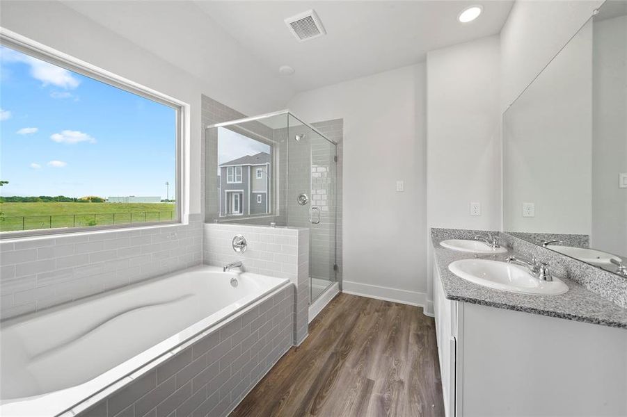 Primary bathroom with double sinks, with standalone shoer and soaking tub .