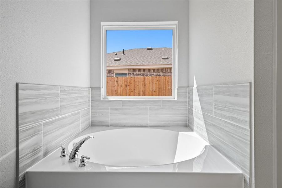 Full bathroom featuring a textured wall and a garden tub Full bathroom featuring a textured wall and a garden tub