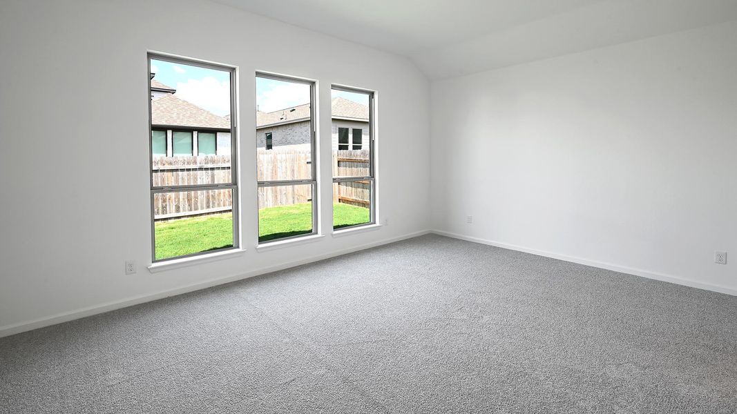 Carpeted spare room featuring lofted ceiling and baseboards Carpeted spare room featuring lofted ceiling and baseboards