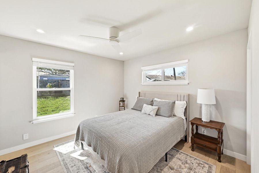 Bedroom featuring ceiling fan, light wood finished floors, multiple windows, and recessed lighting
